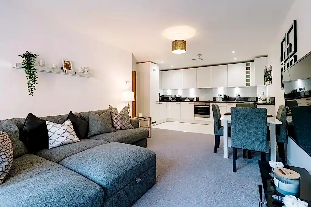 Modern iç mekan tasarımında açık tonlar, doğal ahşap detaylar ve dengeli oturma alanı olan salon